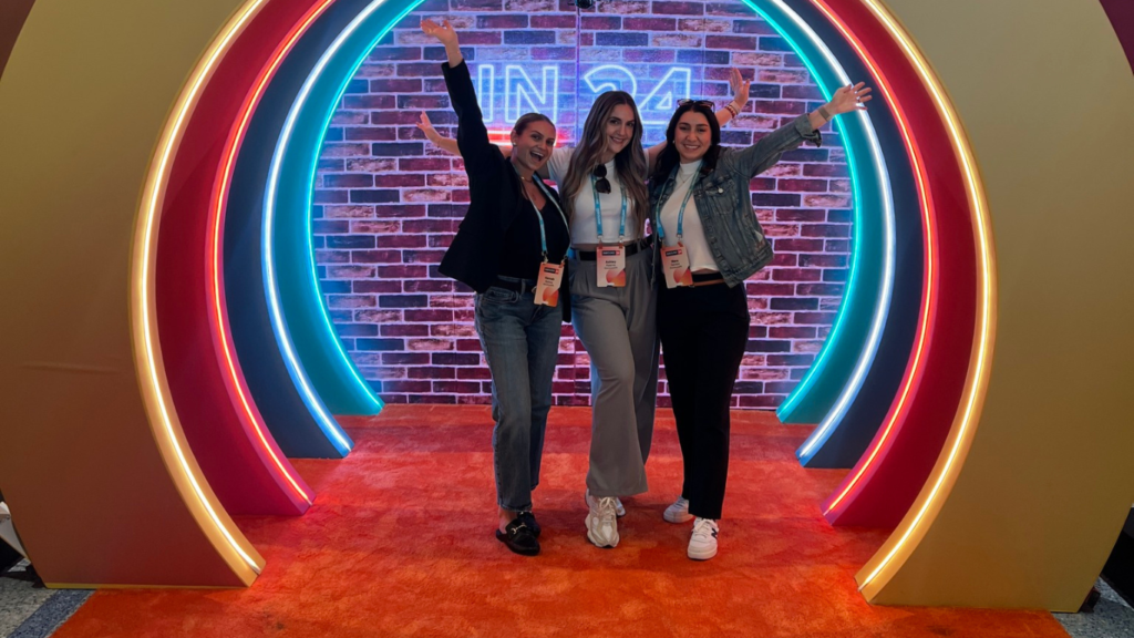 3 girls in front of Inbound conference signage looking excited